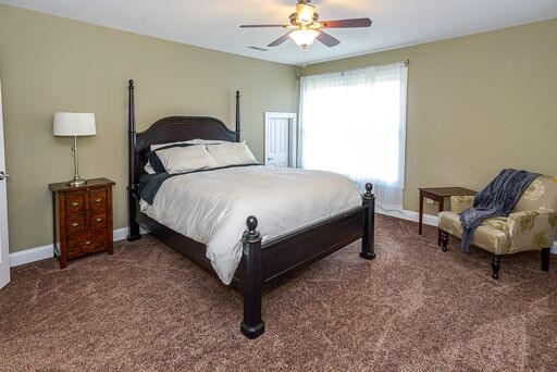 228 Wabash Road Fayetteville, TN 37334 - Photo 19 of 50 a spacious bedroom with a bed and a chandelier