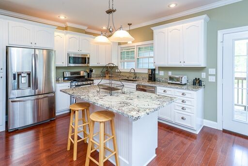 228 Wabash Road Fayetteville, TN 37334 - Photo 23 of 50 a kitchen with stainless steel appliances granite countertop a refrigerator a stove top oven a sink dishwasher and white cabinets with wooden floor