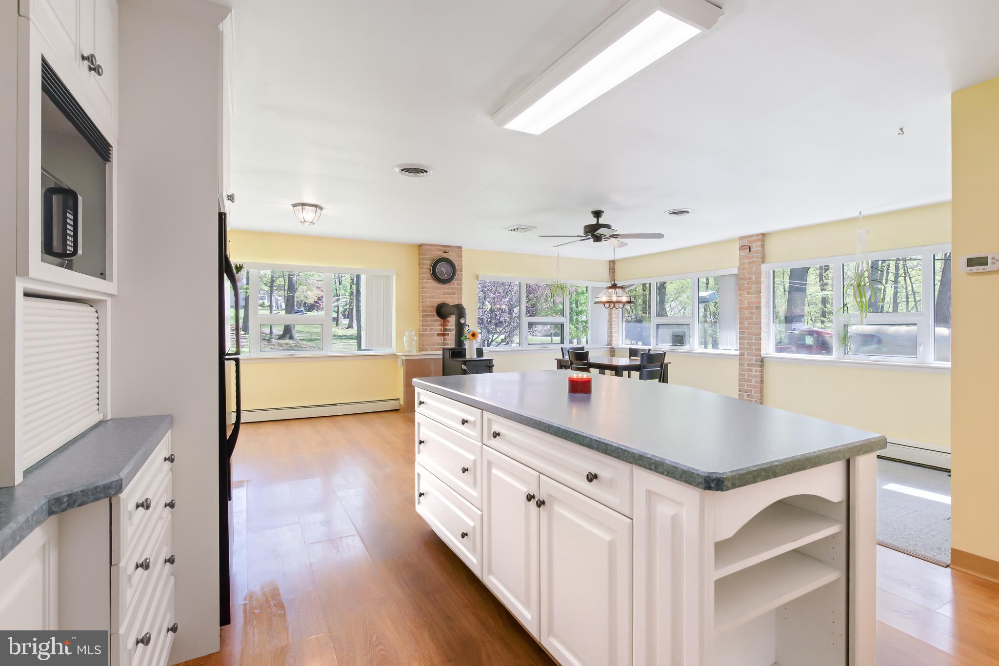 1749 Ramich Road Temple, PA 19560 - Photo 11 of 48 a kitchen with stainless steel appliances granite countertop a sink dishwasher and a dining table with wooden floor