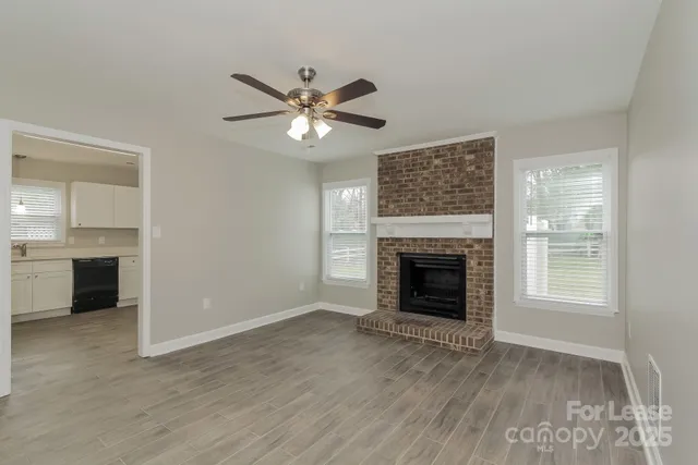 wooden floor fireplace and windows in an empty room
