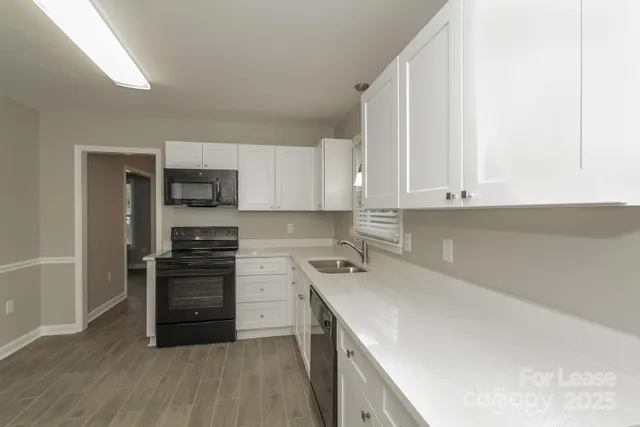 a kitchen with a sink a stove and cabinets