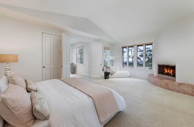 a spacious bedroom with a bed and a fireplace