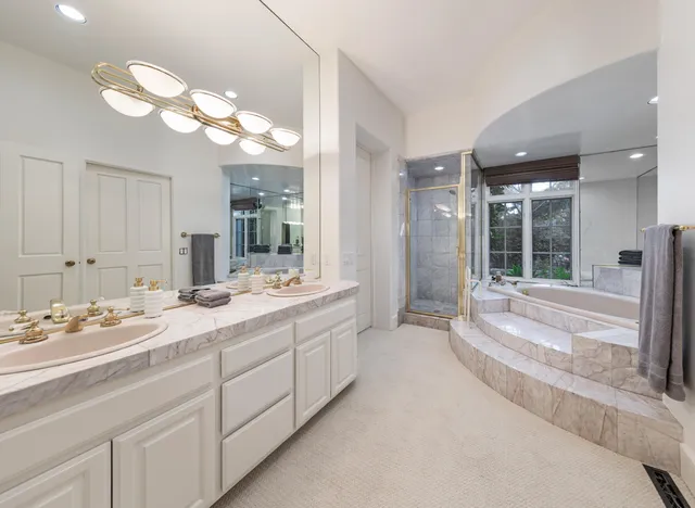 a bathroom with a sink a large mirror and a bathtub