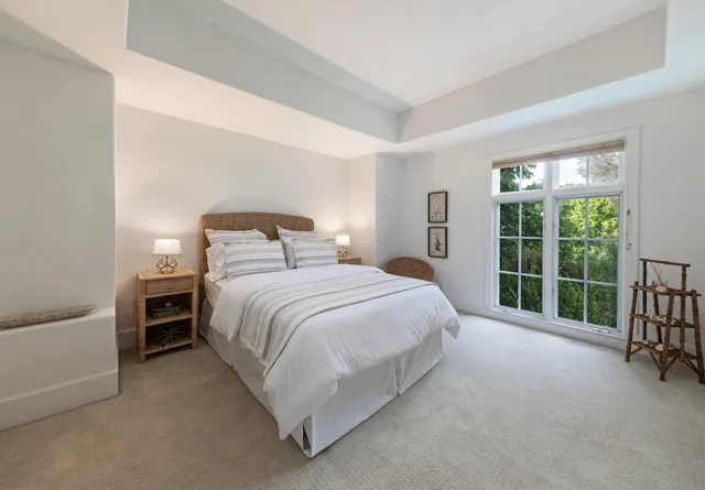 a bedroom with a bed and a large window