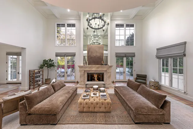 a living room with furniture a fireplace and a large mirror