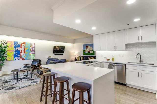 a kitchen with stainless steel appliances a table and chairs in it
