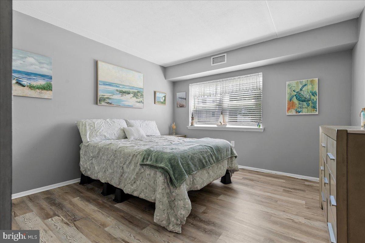 84 Welsh Tract Road, Unit 106 Newark, DE 19713 - Photo 13 of 32 a spacious bedroom with a bed and wooden floor