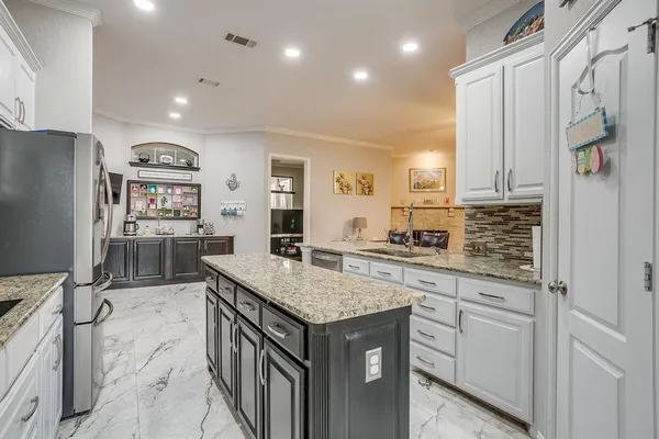a kitchen with granite countertop a sink stove and refrigerator