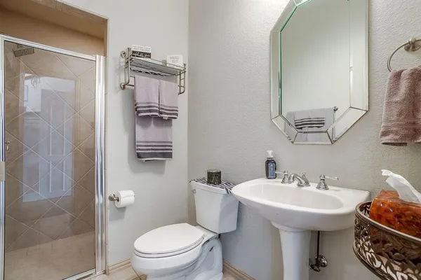 a bathroom with a sink a toilet and shower