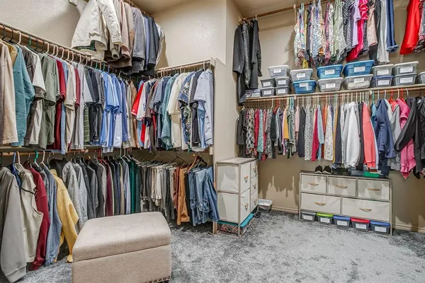 a view of walk in closet with clothes and shoes