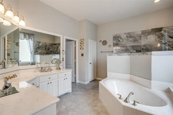a bathroom with a tub sink and mirror