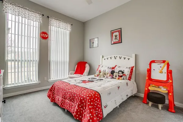 a bedroom with a bed and a white cabinet