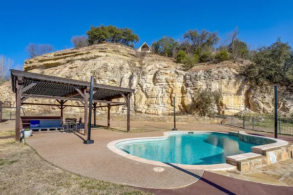 a view of a swimming pool with a patio and a yard
