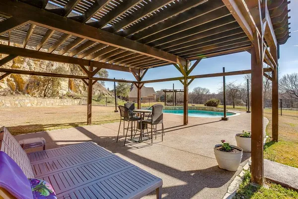 a roof deck with table and chairs and potted plants