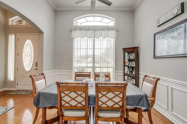 a view of a dining room with furniture a chandelier and wooden floor
