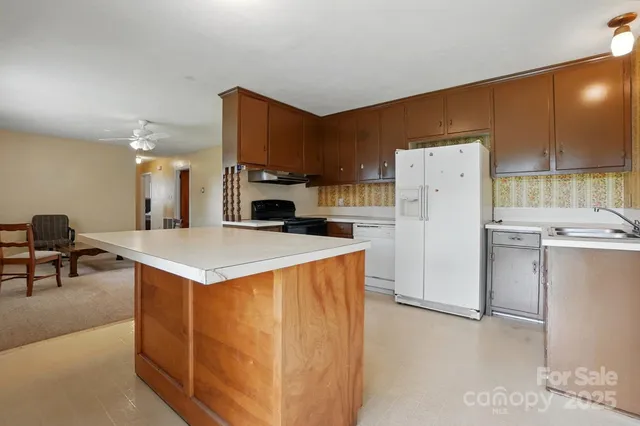 a kitchen with a refrigerator a stove and a dining table
