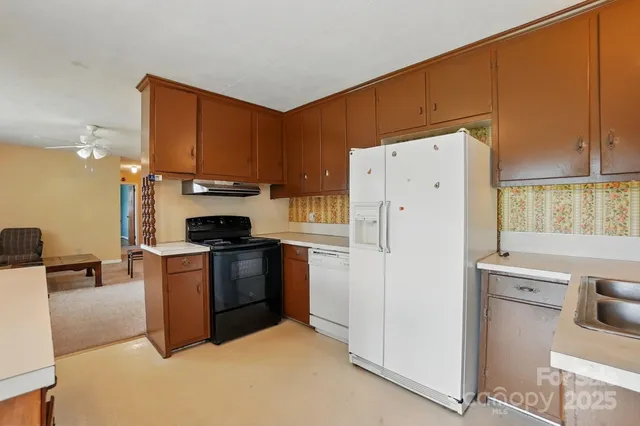 a kitchen with a refrigerator a stove a sink dishwasher and cabinets with wooden floor