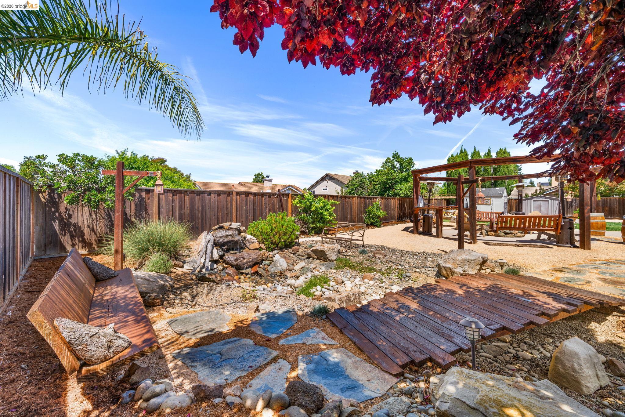 1186 El Rio Court Livermore, CA 94551 - Photo 39 of 60 Expansive backyard featuring a pergola, stone pathway, and a wooden bridge