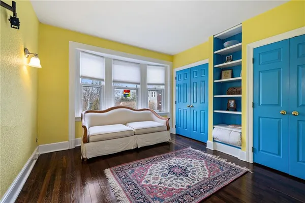 a bedroom with a bed closet and wooden floor