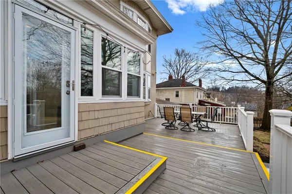a view of a patio with table and chairs with wooden floor and fence