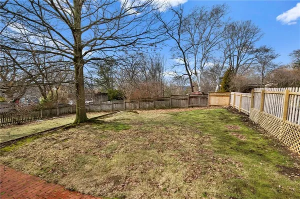 a view of backyard with wooden fence