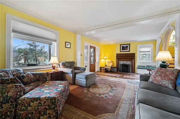 a living room with furniture large window and a fireplace