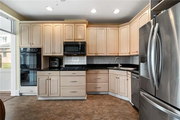a kitchen with stainless steel appliances granite countertop a refrigerator sink and cabinets