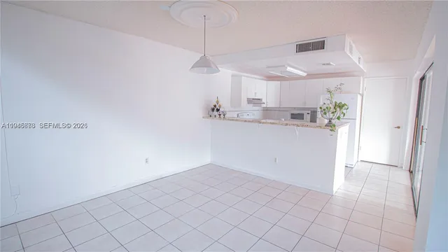 a view of a kitchen with a sink dishwasher white cabinets and a refrigerator