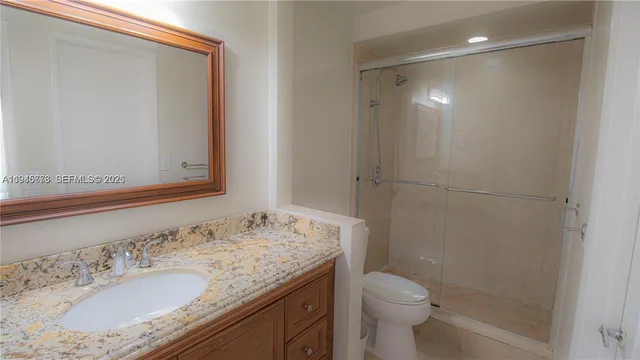 a bathroom with a granite countertop sink toilet and shower