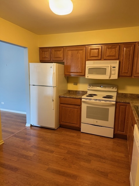 801 79th Street, Unit 310 Darien, IL 60561 - Photo 7 of 18 a kitchen with a white cabinets and wooden floor
