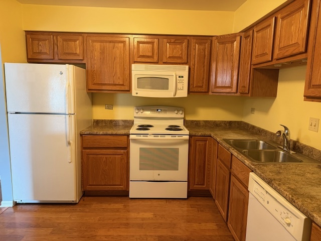 801 79th Street, Unit 310 Darien, IL 60561 - Photo 8 of 18 a kitchen with granite countertop a refrigerator a stove a sink and dishwasher with wooden floor