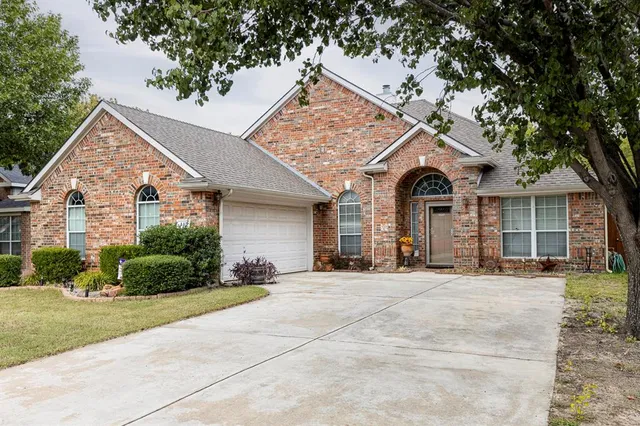 a view of a white house with large windows and a small yard