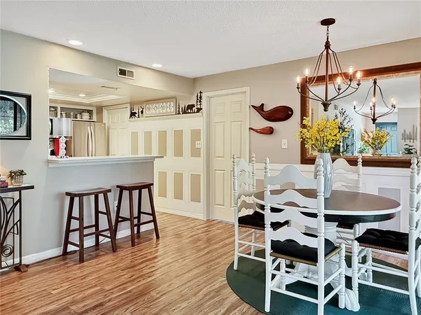 a dining room with furniture a chandelier and wooden floor