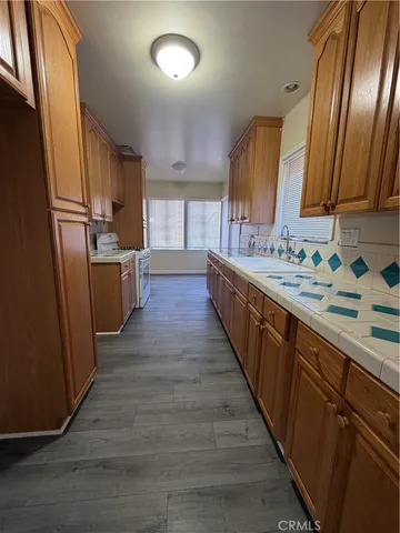 a view of a kitchen counter space wooden floor and stainless steel appliances
