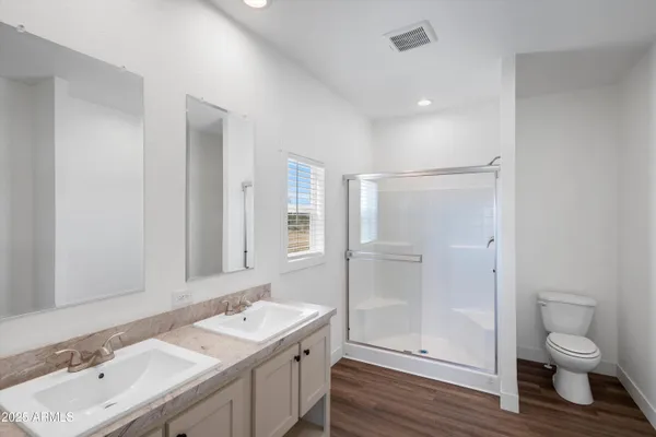 a bathroom with a granite countertop sink a toilet and shower