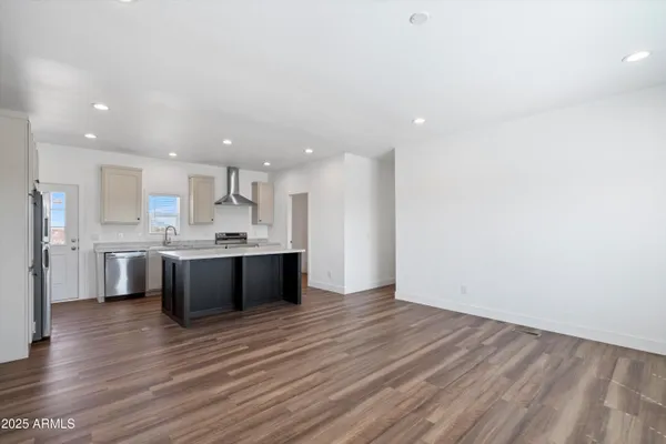 a large kitchen with stainless steel appliances granite countertop a large counter top a sink and a refrigerator