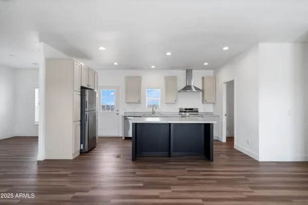 a large kitchen with stainless steel appliances refrigerator sink and cabinets