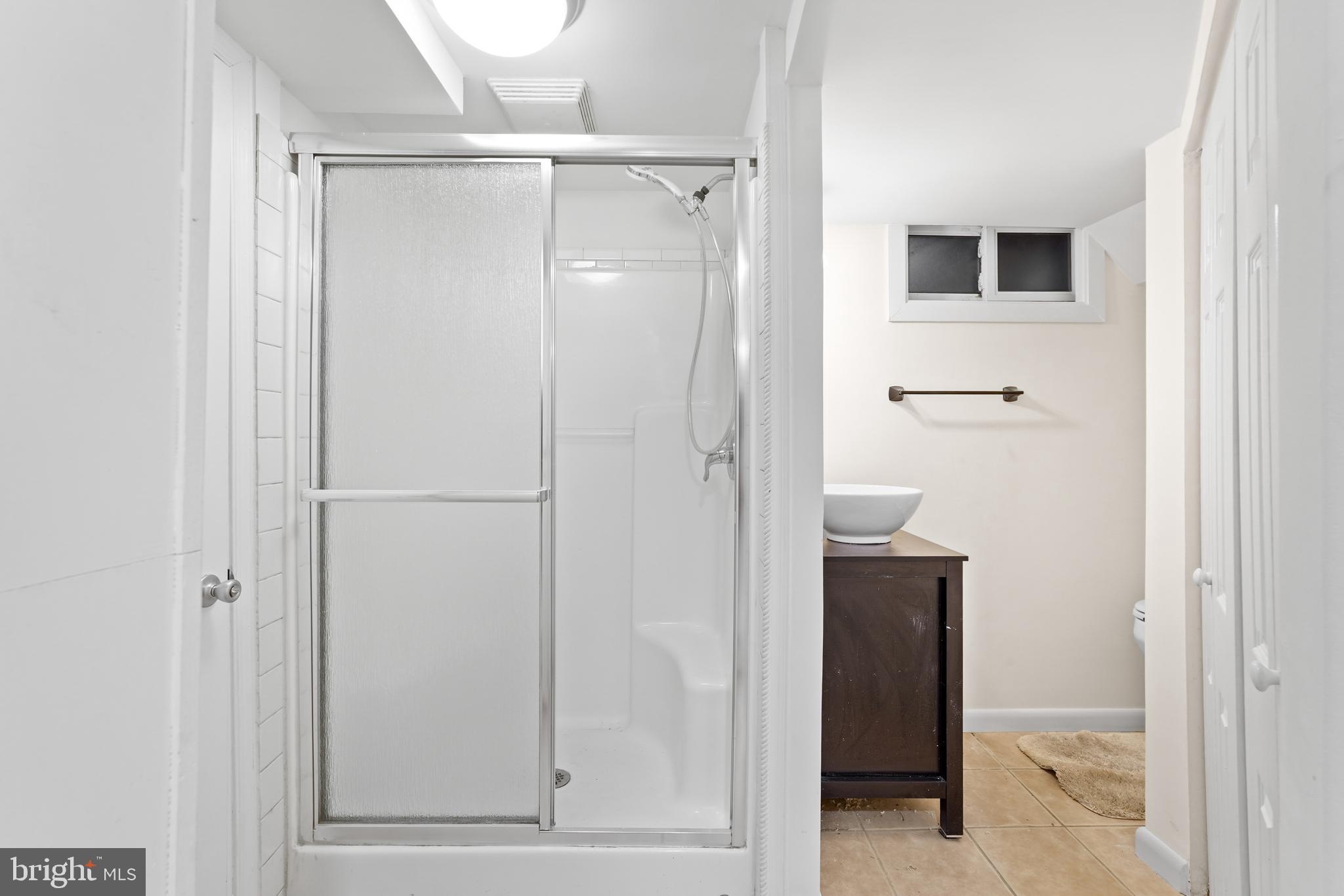 7423 Exmore Street Springfield, VA 22150 - Photo 33 of 39 a bathroom with a glass shower door