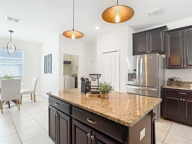 a kitchen with granite countertop stainless steel appliances a stove sink and cabinets