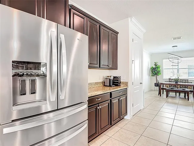 a kitchen with stainless steel appliances granite countertop a stove top oven a sink dishwasher a dining table and chairs