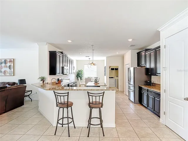 a kitchen with stainless steel appliances granite countertop a sink a stove top oven a counter space and cabinets