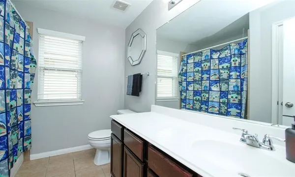 a bathroom with a sink a toilet and a window