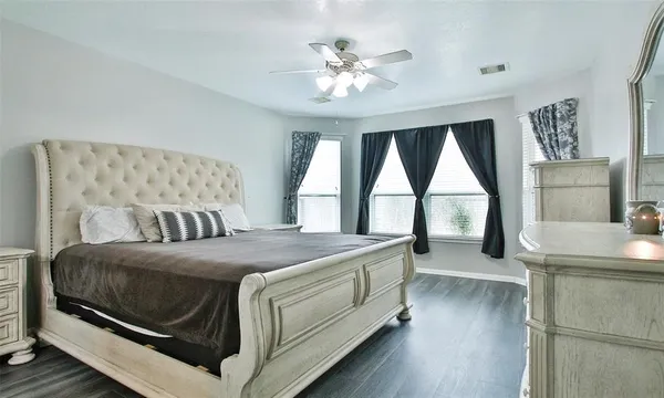 a bedroom with a large bed and a chandelier
