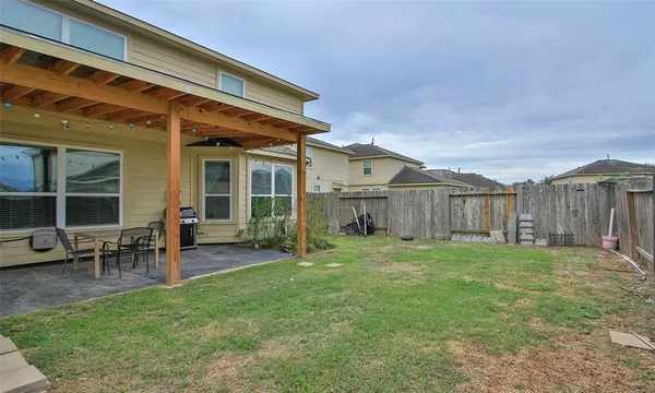 a view of a backyard with table and chairs and wooden fence