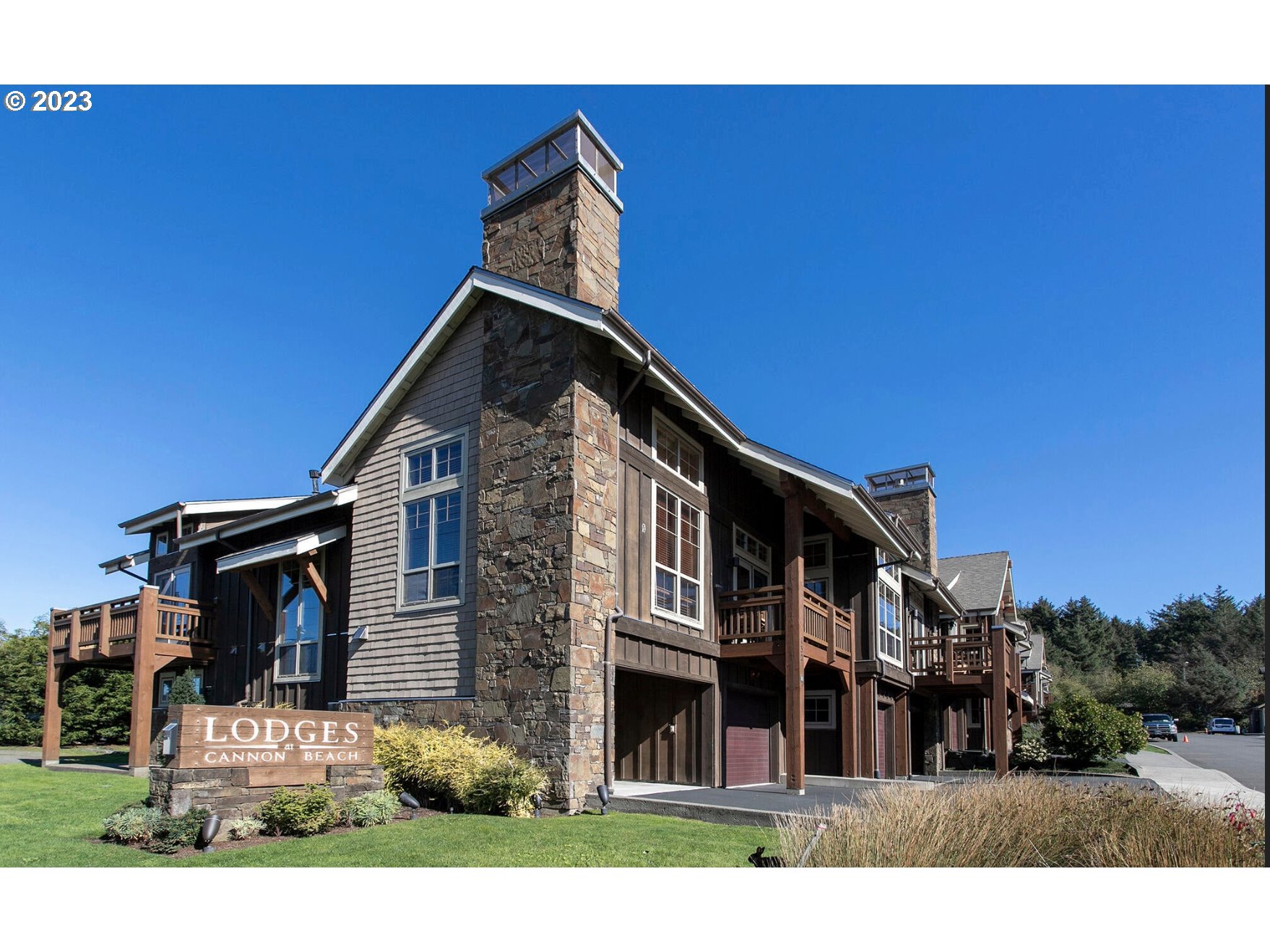 Lodges At Cannon Bea, Unit B2 Cannon Beach, OR 97110 - Photo 1 of 25 a front view of a house with a yard