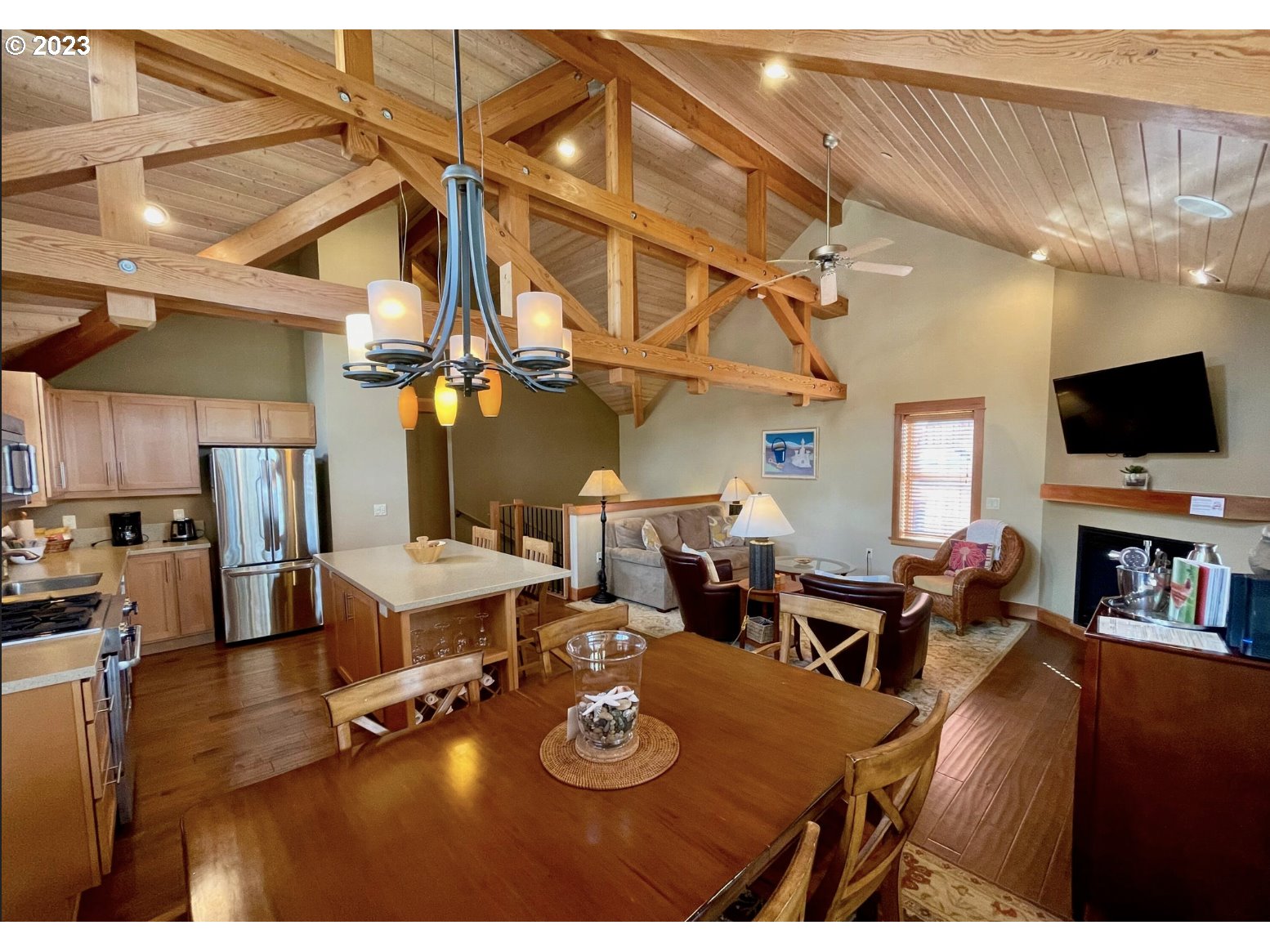 Lodges At Cannon Bea, Unit B2 Cannon Beach, OR 97110 - Photo 13 of 25 a living room with furniture a flat screen tv and kitchen view