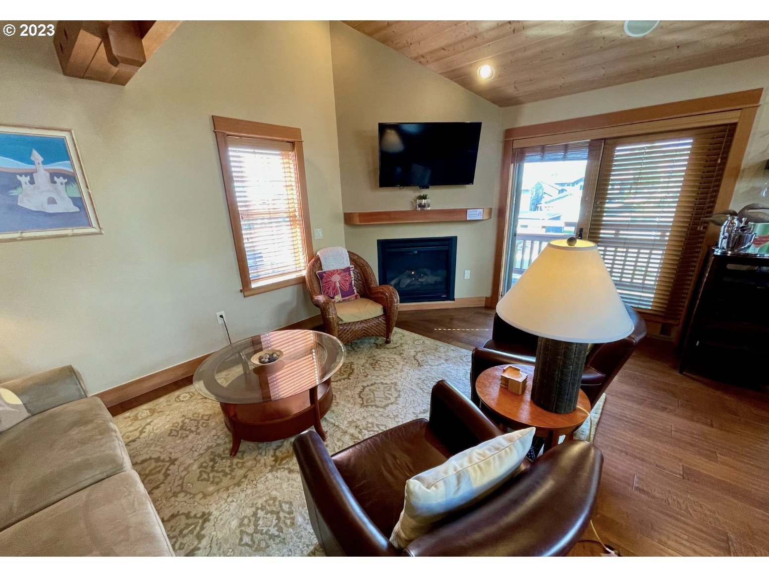 Lodges At Cannon Bea, Unit B2 Cannon Beach, OR 97110 - Photo 15 of 25 a living room with furniture a fireplace and a flat screen tv