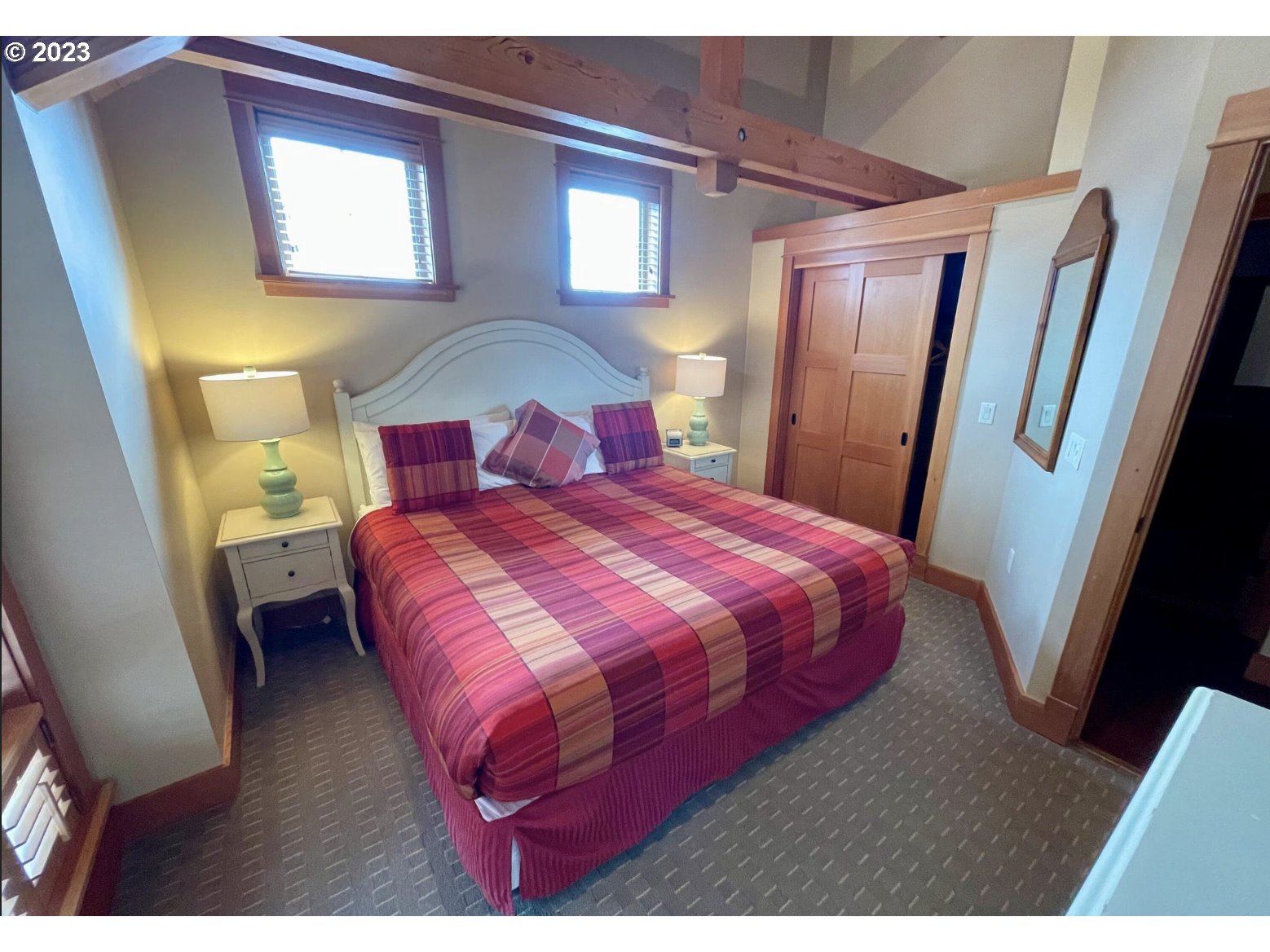 Lodges At Cannon Bea, Unit B2 Cannon Beach, OR 97110 - Photo 21 of 25 a bedroom with a bed and a mirror
