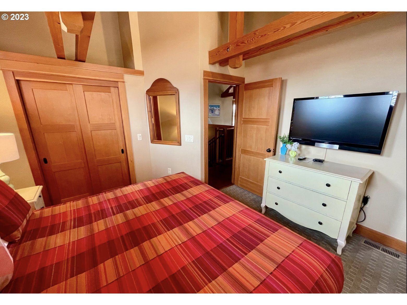 Lodges At Cannon Bea, Unit B2 Cannon Beach, OR 97110 - Photo 22 of 25 a bedroom with a bed and flat screen tv