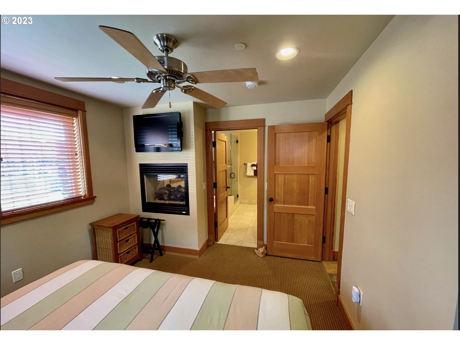 Lodges At Cannon Bea, Unit B2 Cannon Beach, OR 97110 - Photo 5 of 25 a bedroom with a bed and a chandelier